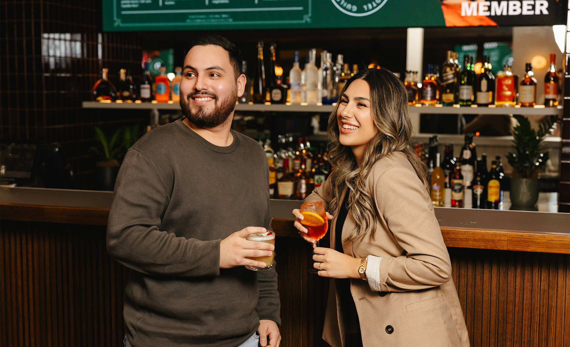 A happy couple standing in front of a bar, enjoying each other's company.